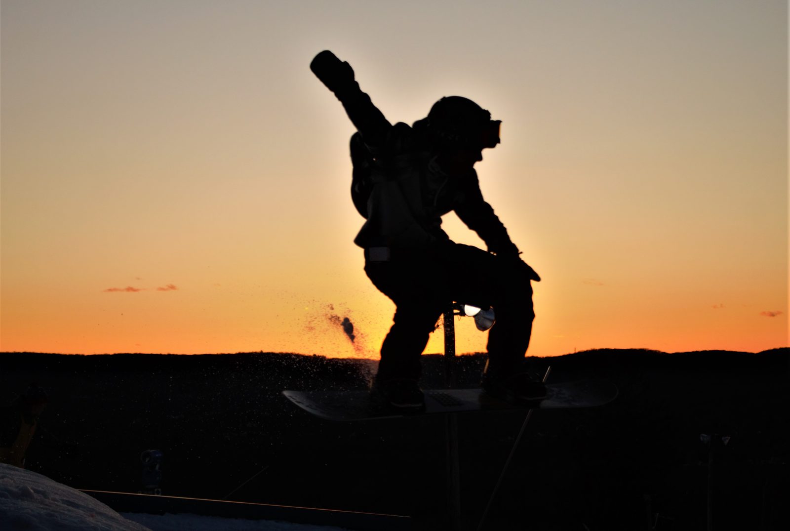A snowboarder catching air off a terrain park jump